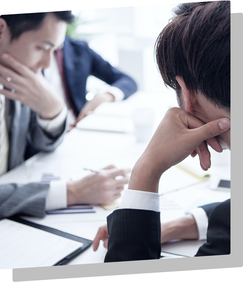 書類を広げて話し合う男性たち